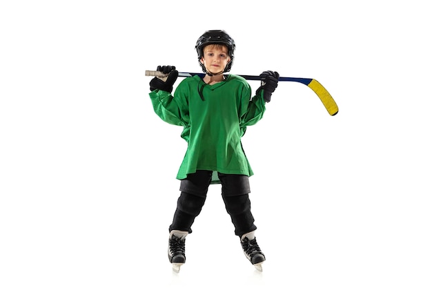 Little hockey player with the stick on ice court, white studio wall