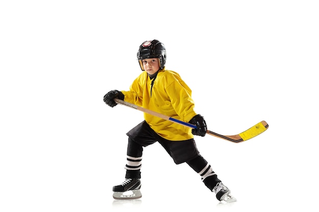 Little hockey player with the stick on ice court and white 