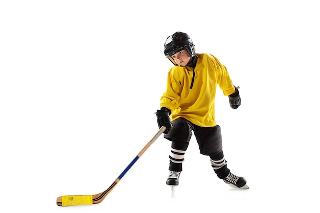 Little hockey player with the stick on ice court and white