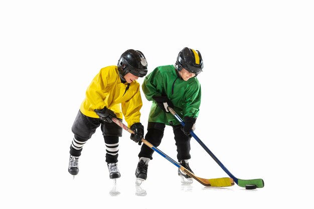 Little hockey players with the sticks on ice court and white  background.