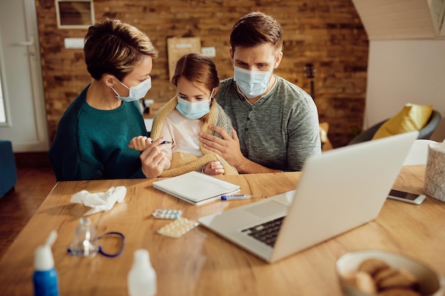 코로나바이러스 전염병으로 인해 집에서 안면 마스크를 쓰고 있는 어린 소녀와 그녀의 부모