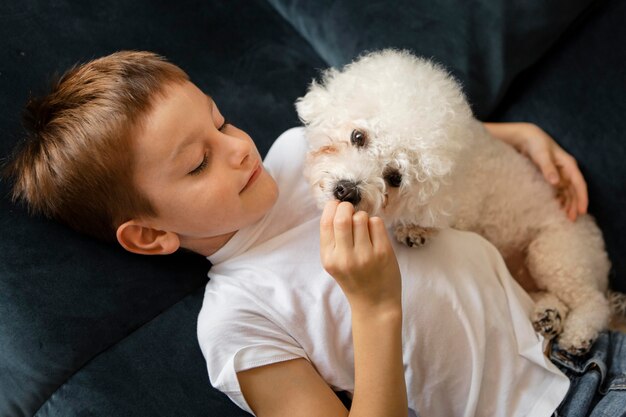 Little kid having fun with his dog at home