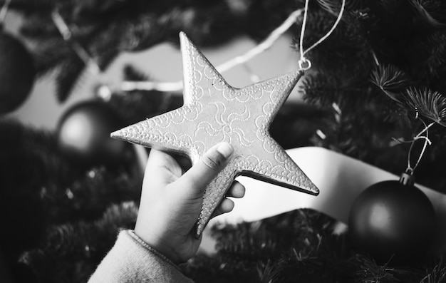 Ragazzino che tiene un ornamento stella albero di natale