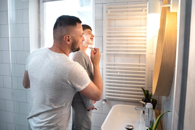 Little kid learning how to shave medium shot