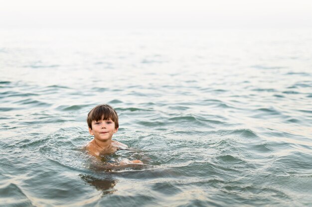 Маленький ребенок позирует в море
