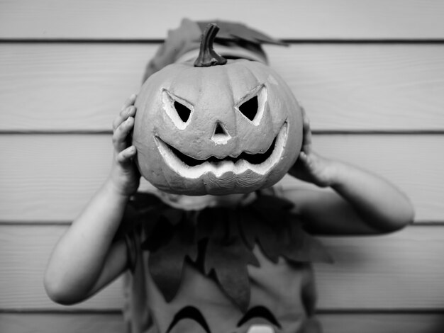 Little kid with Halloween pumpkin