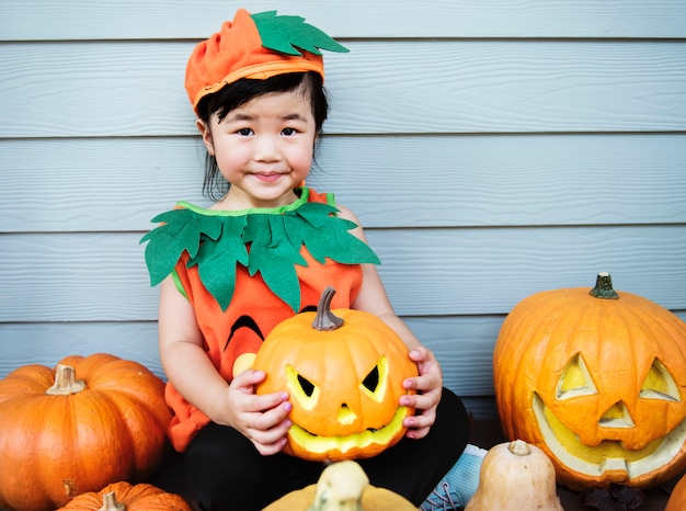 Little kid with Halloween pumpkin