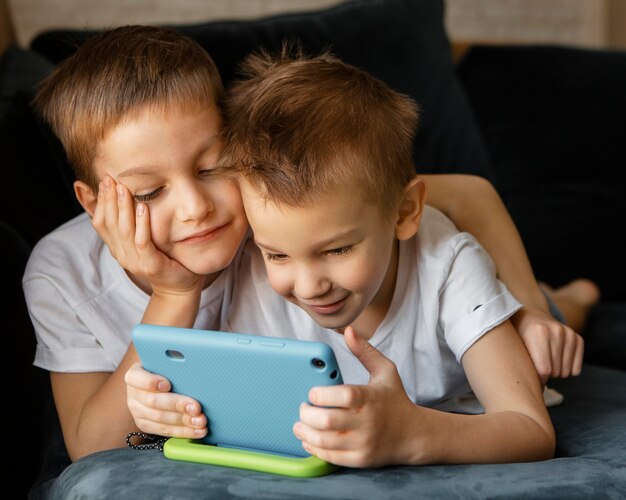 little kids looking together on the phone at home