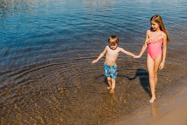 Free photo little kids walking along beach