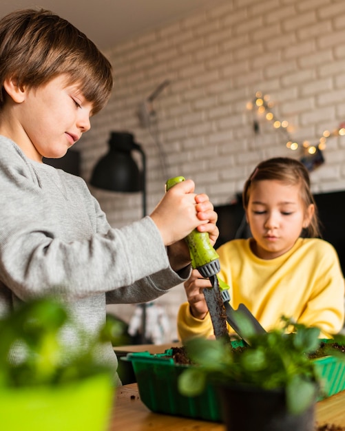 Free photo little kids watering crops at home