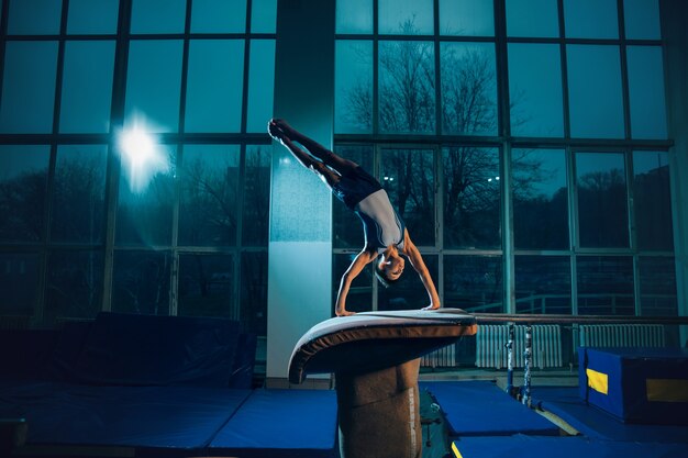 Little male gymnast training in gym flexible and active