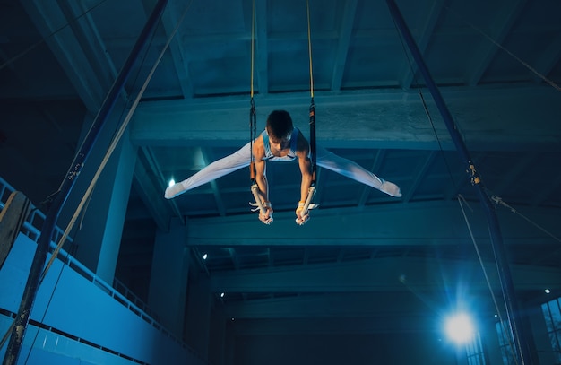 Little male gymnast training in gym