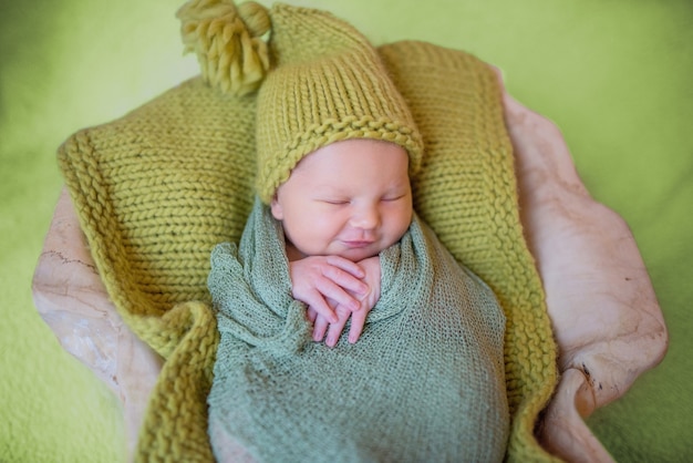 Free photo little newborn baby in knitted clothes sleeps on the pillow