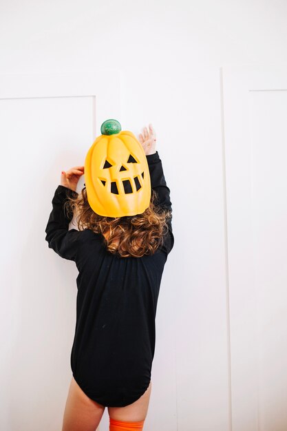 Little pumpkin looking at white wall