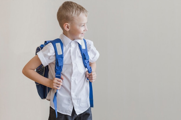 Little pupil with backpack in studio