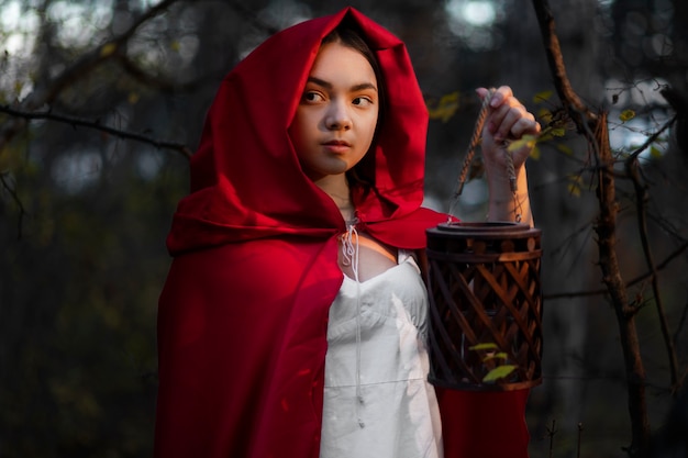 Free photo little red riding hood in the forest portrait