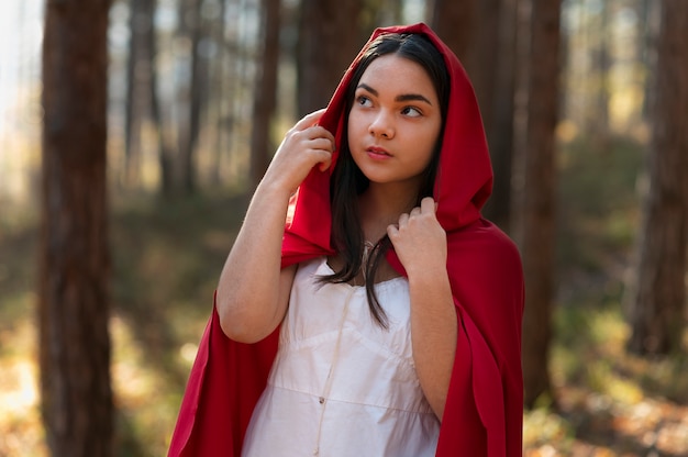 Free photo little red riding hood in the forest portrait