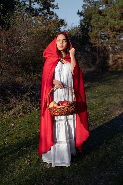 Little red riding hood with wooden basket with goodies