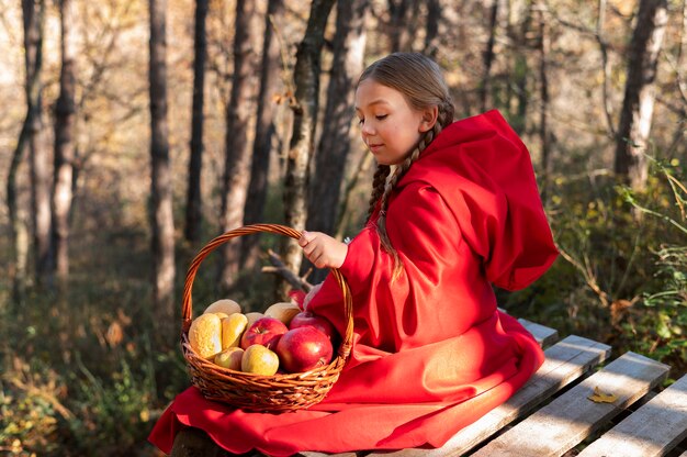 Little red riding hood with wooden basket with goodies