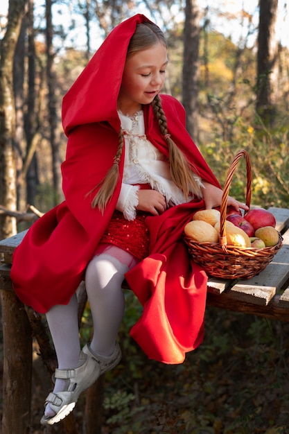 Little red riding hood with wooden basket with goodies