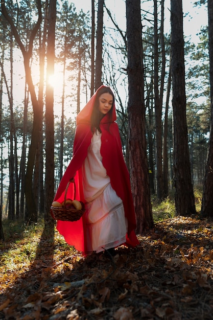 Little red riding hood with wooden basket with goodies