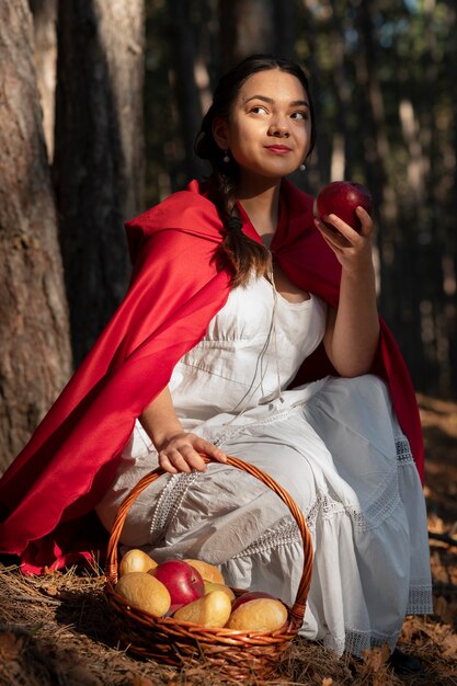 Little red riding hood with wooden basket with goodies