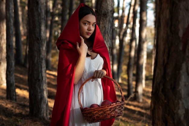 Little red riding hood with wooden basket with goodies