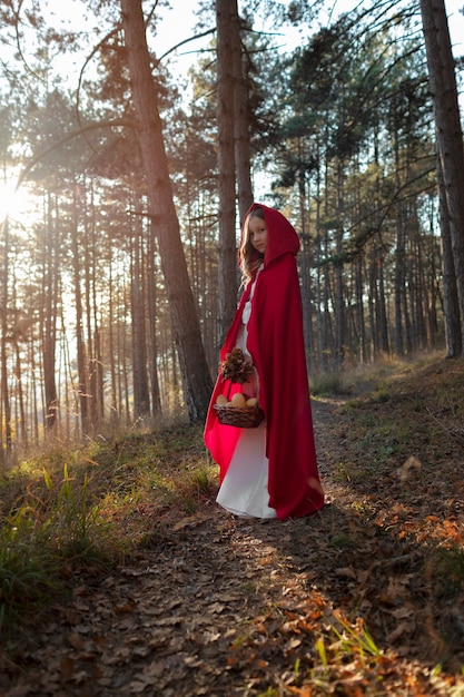 Little red riding hood with wooden basket with goodies