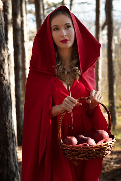 Little red riding hood with wooden basket with goodies