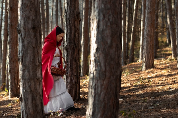 Free photo little red riding hood with wooden basket with goodies