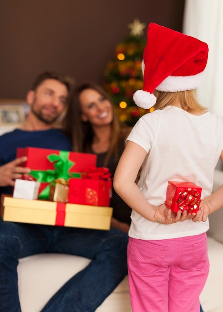 Little santa claus has small gift for parents