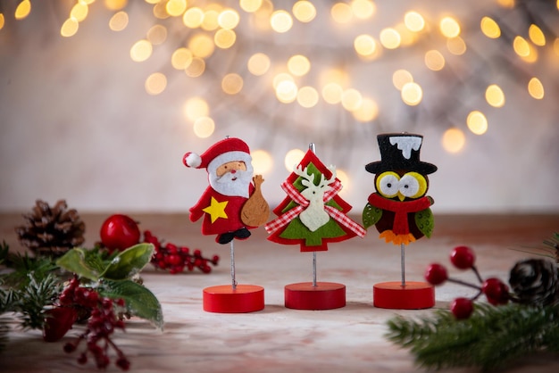 Free photo little santa decoration with owl figure and xmas tree christmas texture on blurred background