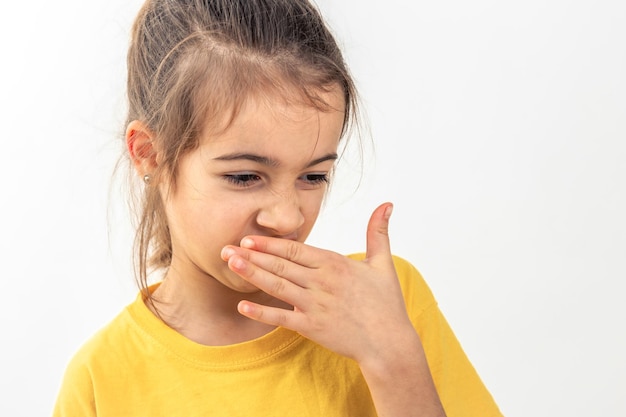 Foto gratuita piccola scolaressa che si sente male e non ama gli odori isolata su uno sfondo bianco