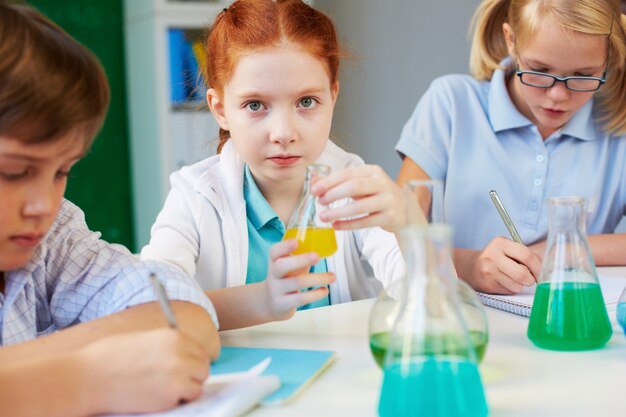 Little scientist playing with a yellow liquid