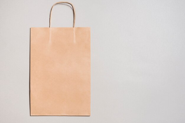 Download Premium Photo Human Hand Holding Green Paper Shopping Bag On Yellow Backdrop Yellowimages Mockups