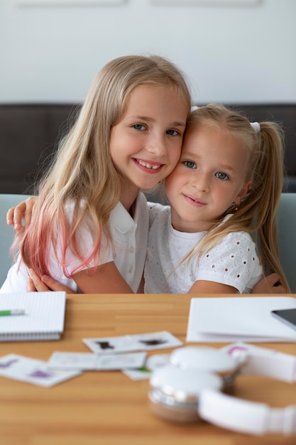 Sorelline che fanno scuola online insieme a casa