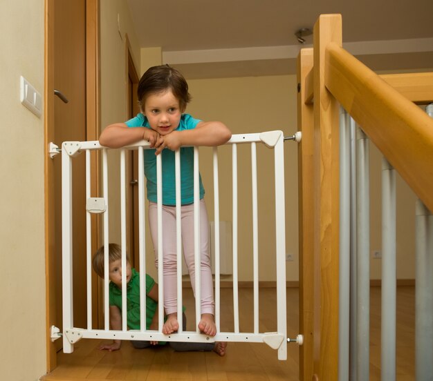 Little sisters near stair gate