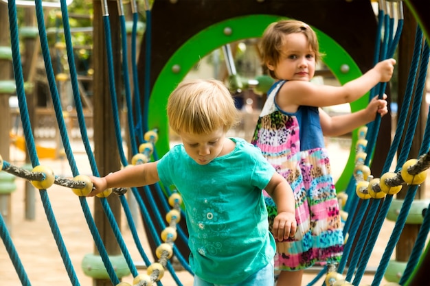 Foto gratuita piccole sorelle al parco giochi nel parco