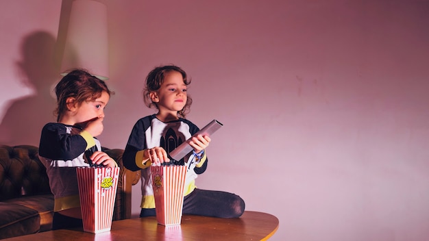 Free photo little sisters watching tv in dark