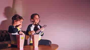 Free photo little sisters watching tv in dark