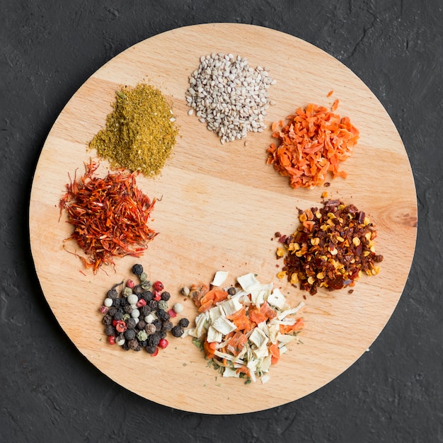 Free photo little spice piles on wooden tray