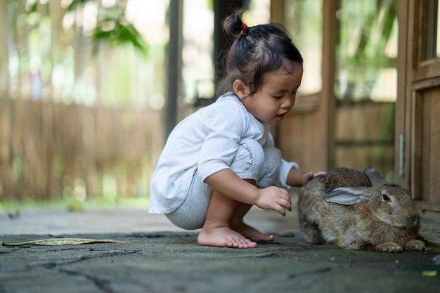 little thai girl playing with a rabbit