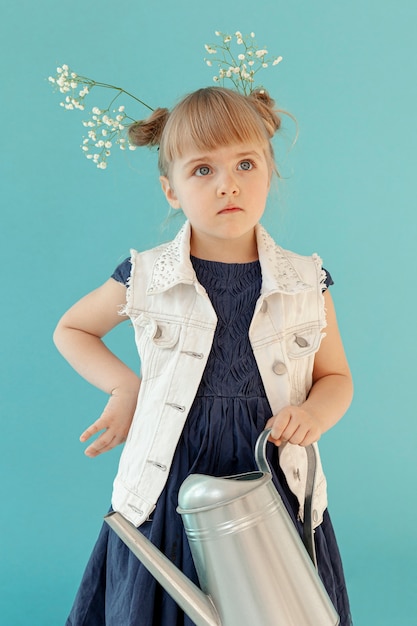 Foto gratuita piccolo bambino che posa con i fiori della molla