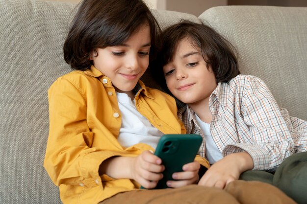 Little twins playing on a smartphone