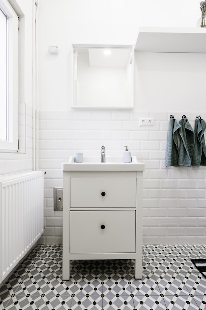 Free photo little white drawer in a white bathroom with hygiene care items on it