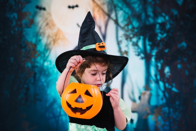 Little witch showing her basket