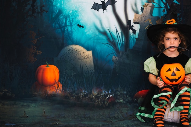 Little witch sitting on pumpkin