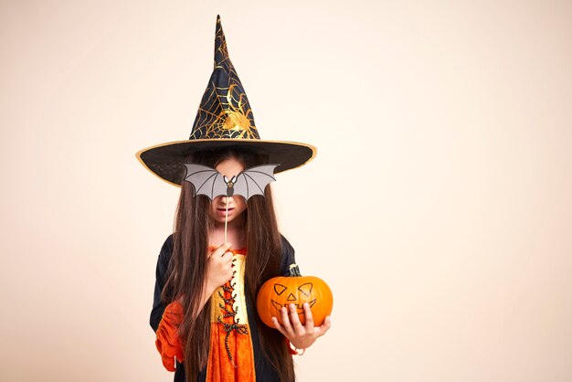 Little witch with halloween pumpkin