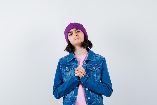 Little woman showing clasped hands in pleading gesture looking hopeful