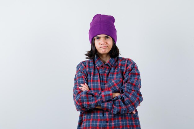 Little woman standing with crossed arms in checkered shirt